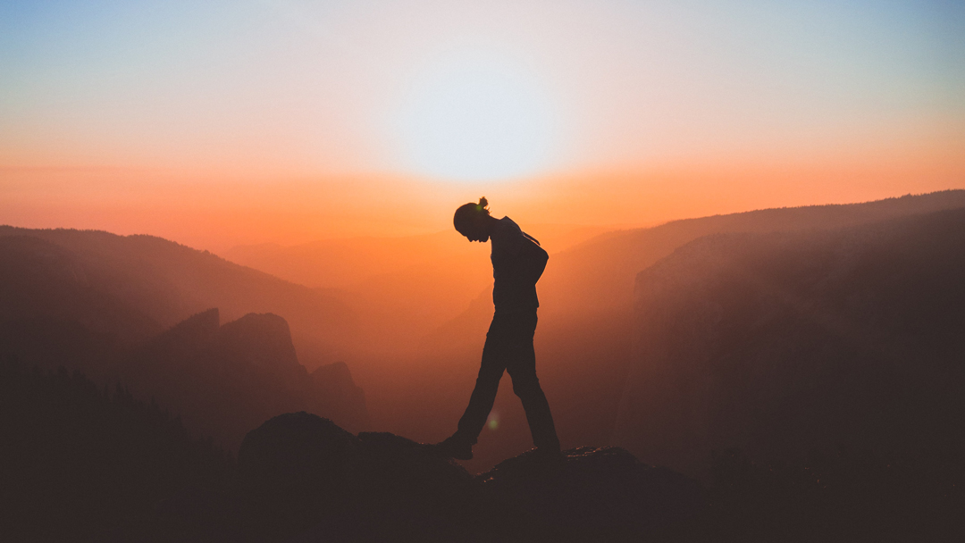 Person walking on rocks during sunset