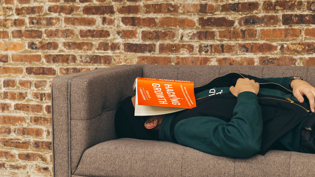 man sleeping with a book on his face