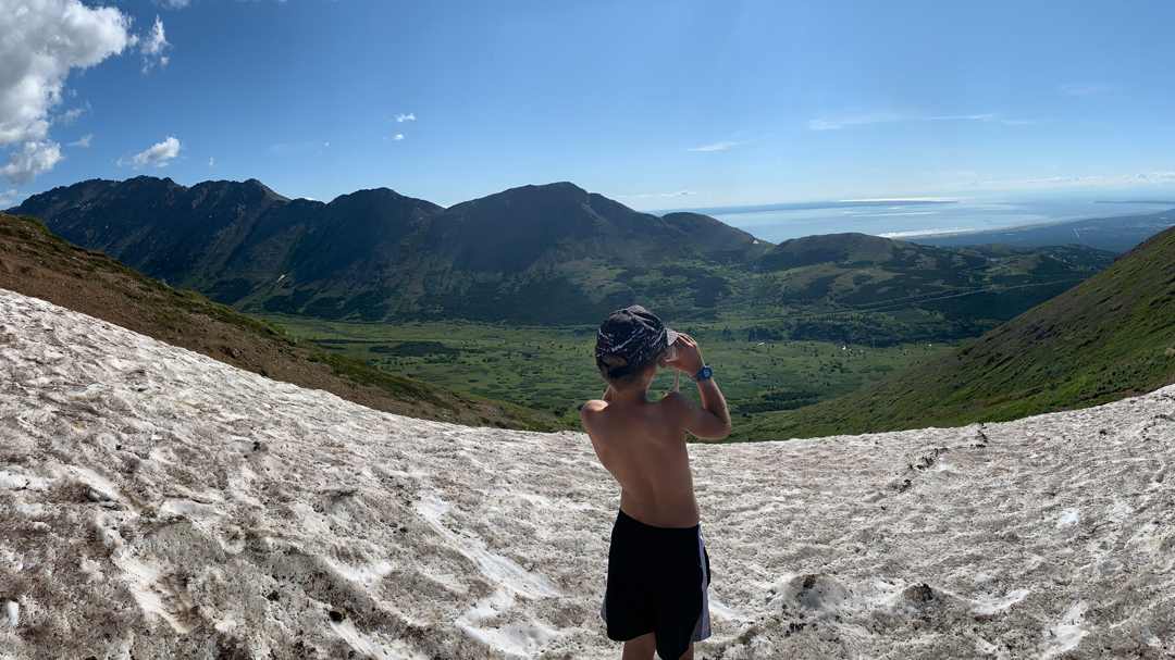 Boy looking at a mountain scape after a hike