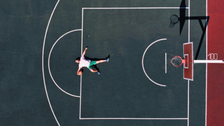 Man laying down on basketball court after playing