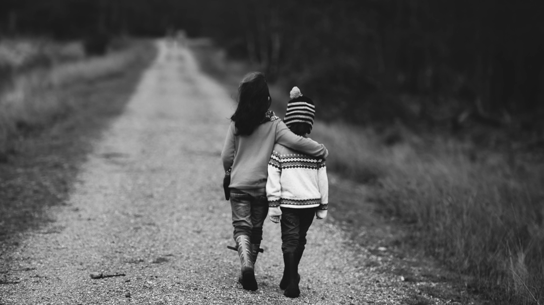 two kids walking with arms around each other