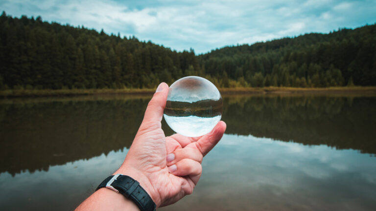 man holding a glass ball