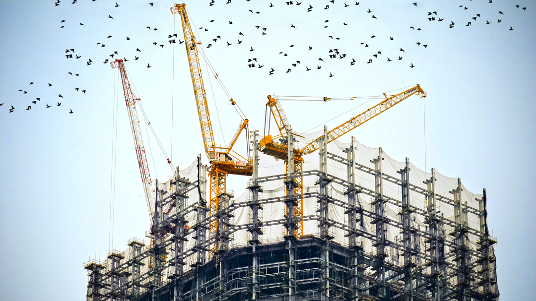 Three cranes on top of a building