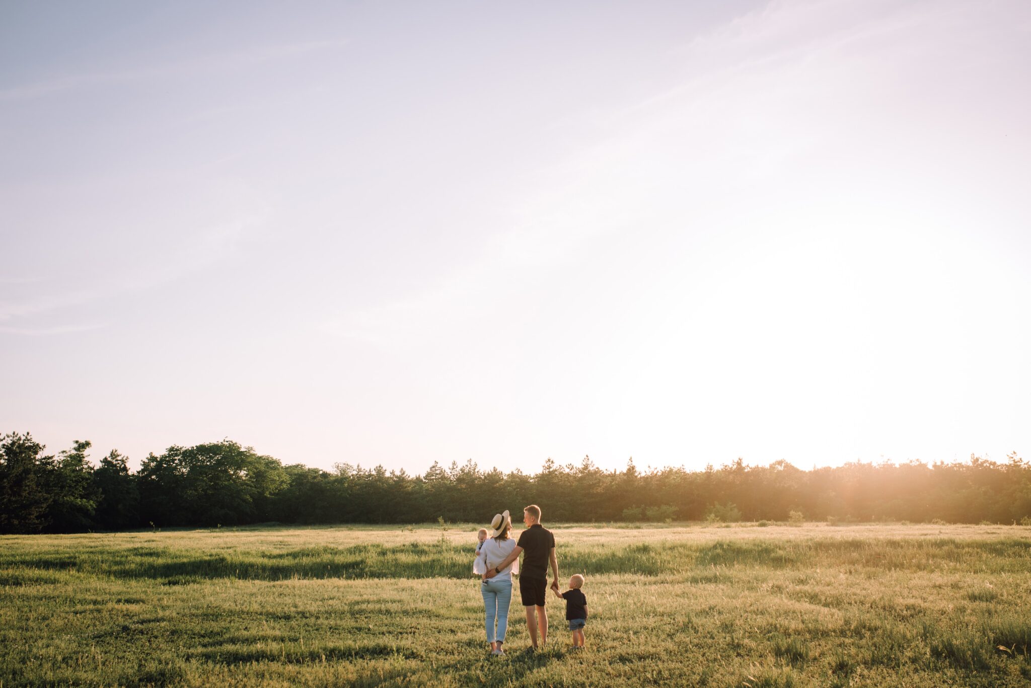 Family walking in a grass field