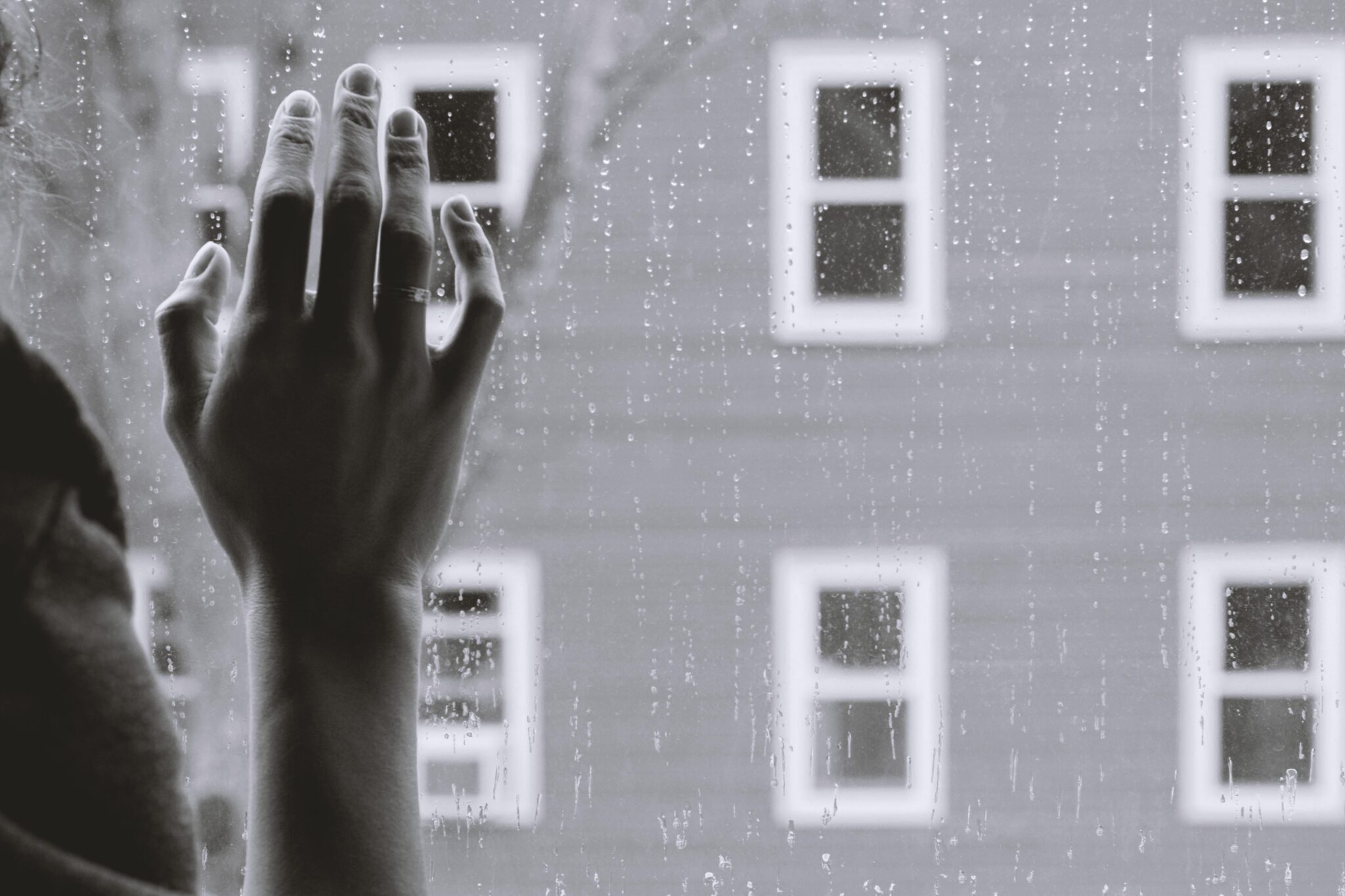 Woman looking outside a rainy window