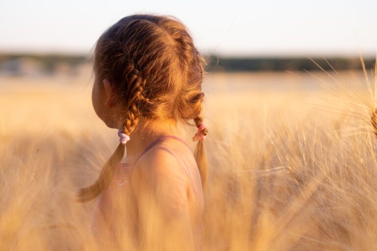 Little girl walking through tall grass