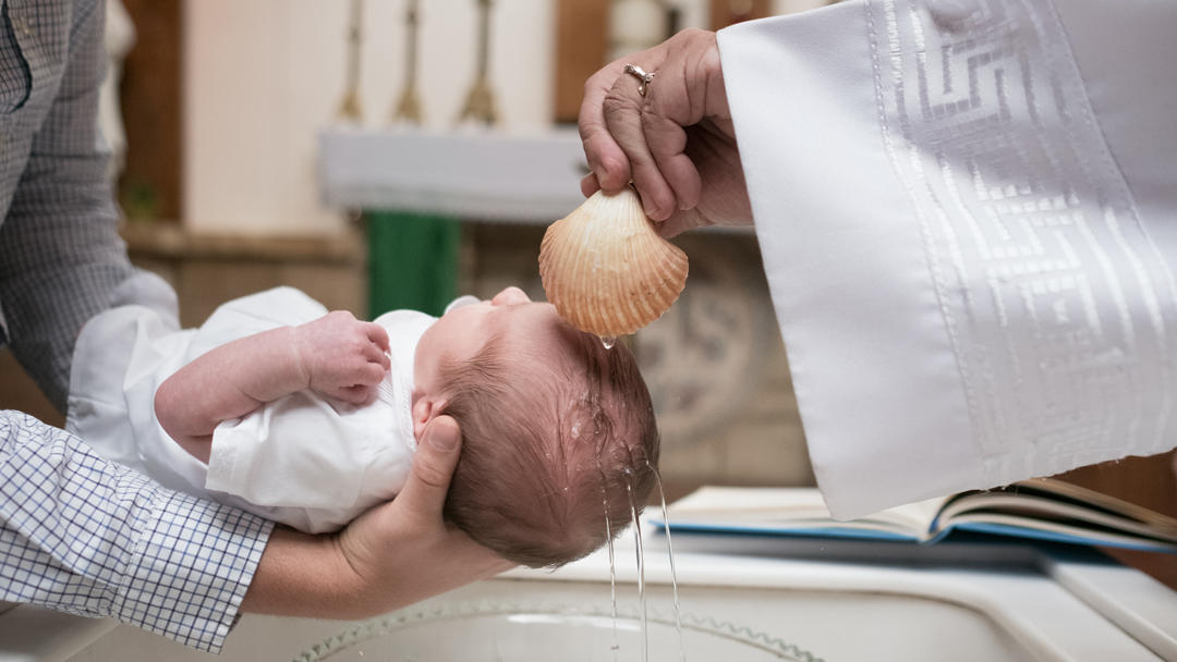 Baby being baptized with a seashell