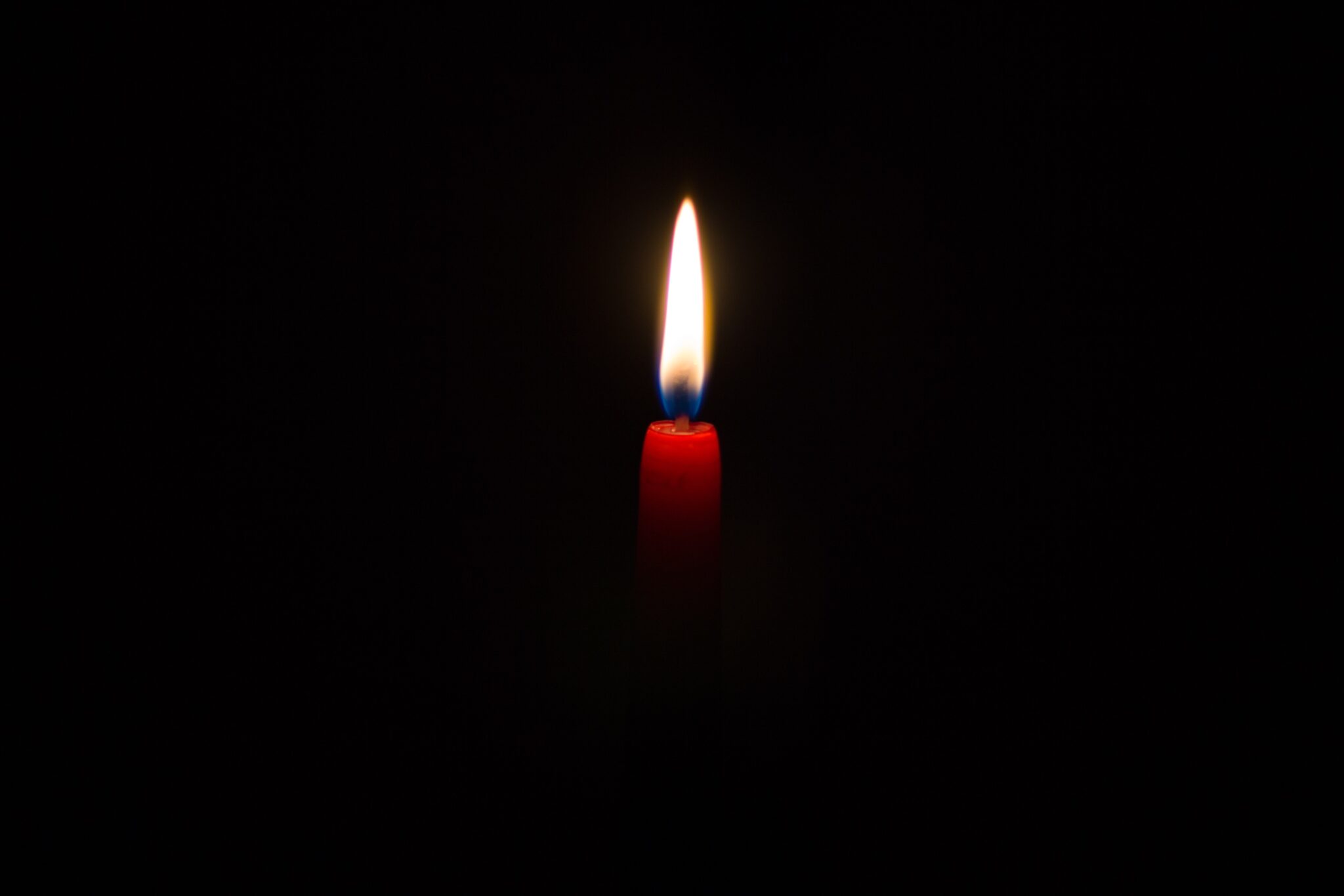 Lit candle in the dark