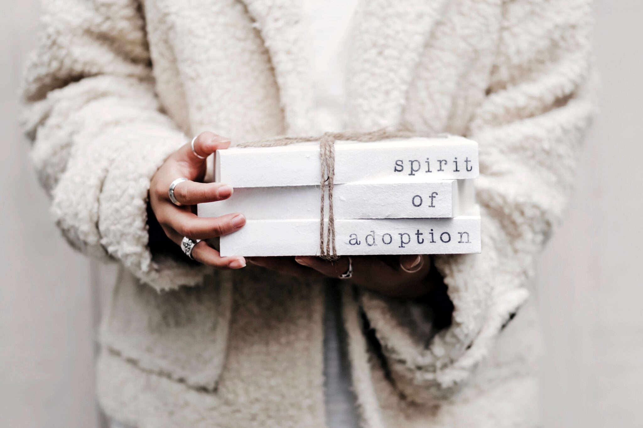 Woman holding white slabs that say Spirit of Adoption