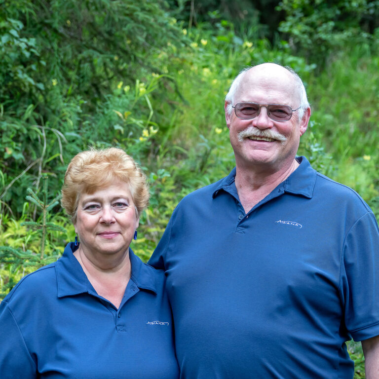 Older couple wearing blue AWANA shirts smiling