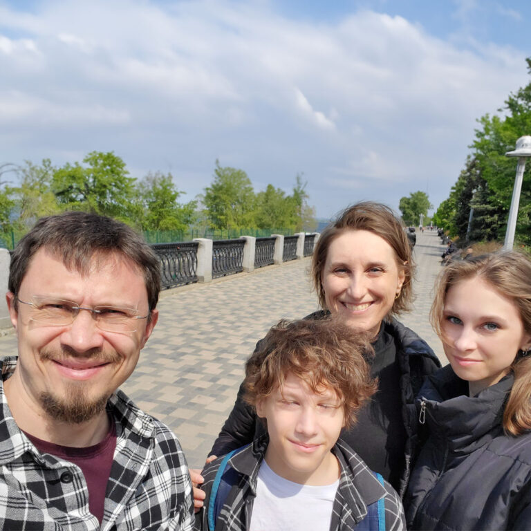 Family of four on a walk with a railing in the background