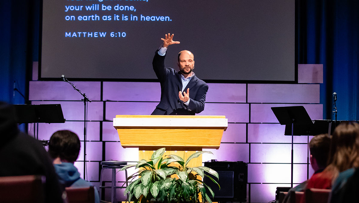 Pastor preaching on stage during Church