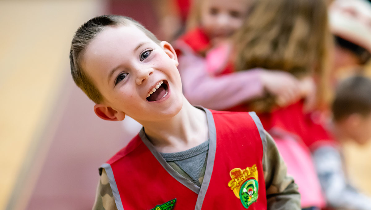 Little boy smiling wearing Awana vest